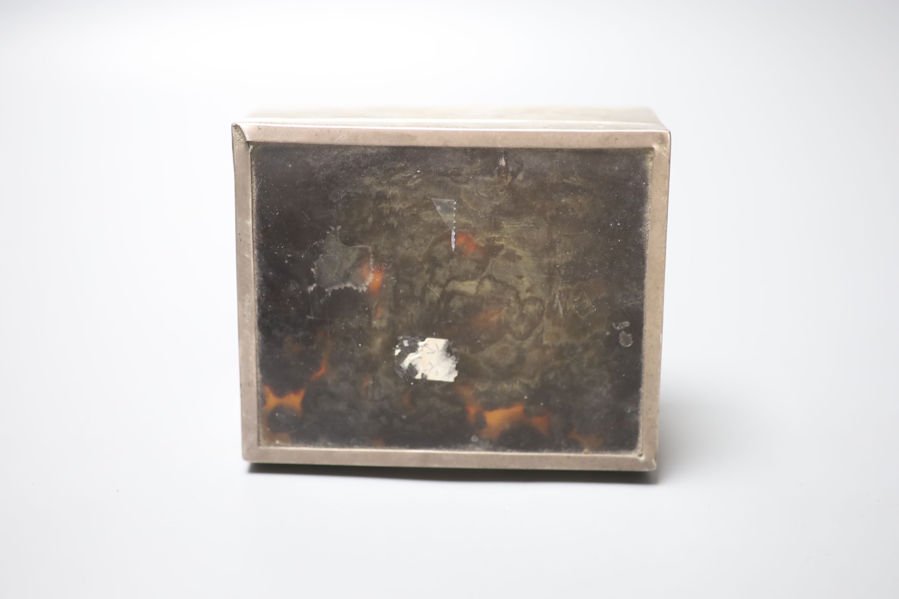 A 1920s silver and tortoiseshell mounted cigarette box, containing a fitted matched silver ashtray and mounted matchbox sleeve,